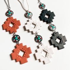 four necklaces with different designs on them