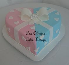 a heart shaped cake with bows and hearts on the top is decorated in pastel colors