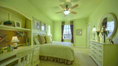 a bedroom with green walls and white furniture