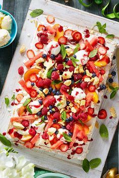 a cake with strawberries, blueberries and other fruit toppings