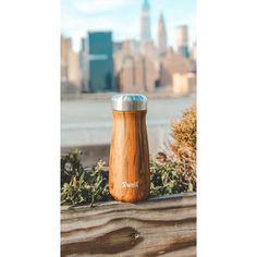 a wooden container sitting on top of a wooden fence next to a large cityscape