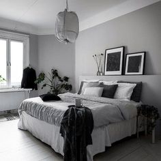 a bed sitting in a bedroom on top of a hard wood floor next to a window