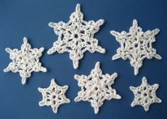 six crocheted snowflakes on a blue background