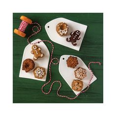 three white trays with different types of cookies on them and twine spools