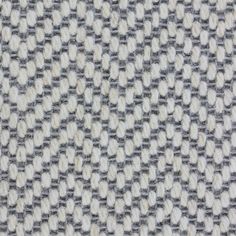 an up close shot of the texture of a tweed fabric with white and grey colors