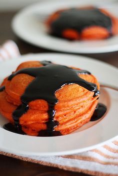 a plate topped with pancakes covered in chocolate sauce