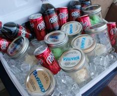 an ice chest filled with cans and cans of sodas on top of ice cubes