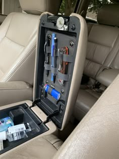 the inside of a car with tools and other items in its back seat trays