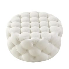 the foot stool is made out of white fabric and has buttons on it's sides