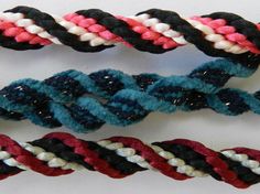 three different colored braids on a white surface with black, red, and blue colors