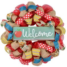 a welcome sign is hanging on the front door with burlocks and ribbon around it