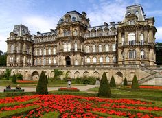 a large building with lots of flowers in front of it