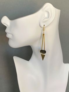 a white mannequin head with a pair of earrings hanging from it's ear