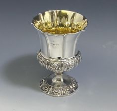 an ornate silver vase with gold in it