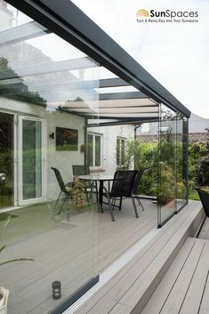 an outdoor patio with glass walls and wooden decking