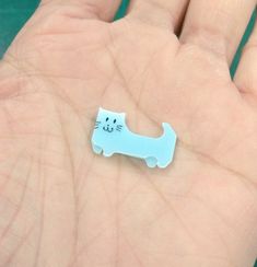 a small plastic cat sitting on top of a hand