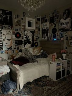 a bed room with a neatly made bed and lots of pictures on the wall