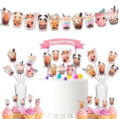 a birthday cake with cupcakes on it and decorations in the shape of animals