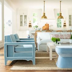 a living room filled with white furniture and lots of light blue accents on the walls