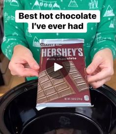 a person holding a box of hershey's chocolate in front of a slow cooker