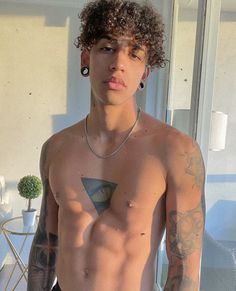 a shirtless man with tattoos on his chest