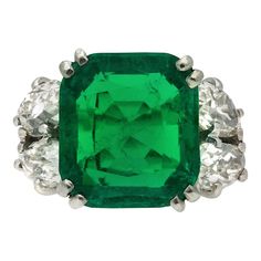 Boucheron Colombian emerald and diamond ring. Centrally set with a cushion shape old mine cut natural Colombian emerald with indications of minor clarity enhancement in an open back claw setting with an approximate weight of 6.20 carats, further adorned with four drop shape old mine diamonds in open back claw settings with a combined approximate weight of 2.10 carats, to an impressive flanked solitaire design featuring double corner claws, a linear pierced gallery and open backholing, the raised Antique Emerald Ring, David Morris, 1920 Art, 1920 Art Deco, Emerald And Diamond Ring, Wedding Ring For Her, Gem Diamonds, Emerald Diamond Ring, Detailed Jewelry