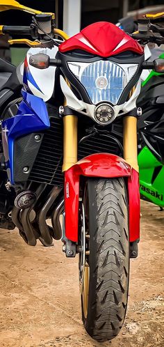 a red, white and blue motorcycle parked next to other motorcycles