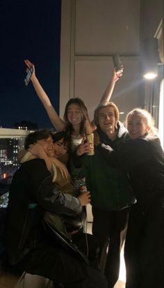 group of people taking selfies in the city at night