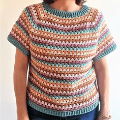 a woman wearing a multicolored crochet sweater with short sleeves and a round neck