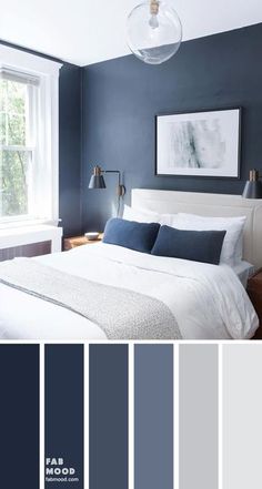 a bedroom with dark blue walls and white bedding