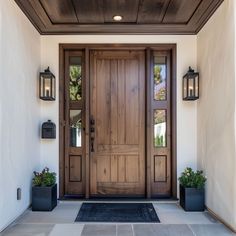 a wooden door with two planters on either side and one light on the wall