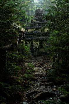 an ancient structure in the middle of a forest with rocks and trees on either side