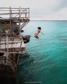 a person jumping into the water from a dock