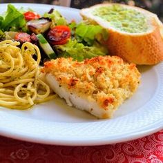 a white plate topped with pasta and meat next to a side of veggies