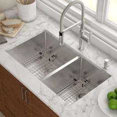 two stainless steel sinks in a kitchen with marble counter tops