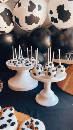 black and white desserts are on display in front of balloons