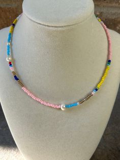 Multicolored seed bead necklace with shades of pink and blues. Accented with freshwater pearls. Pink Heishi Beads Necklace, Pink Heishi Beads Necklace With Tiny Beads, Pink Heishi Beads Beaded Necklace, Pink Pearl Necklace With Colorful Round Beads, Pink Pearl Necklace With Tiny Beads, Handmade Pink Pearl Beaded Necklaces, Adjustable Pink Pearl Necklace With Colorful Beads, Bohemian Pearl Beaded Necklaces With Tiny Beads, Multicolor Pearl Jewelry With Tiny Beads