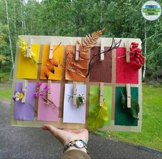 a person holding up a piece of art made out of paper with flowers on it