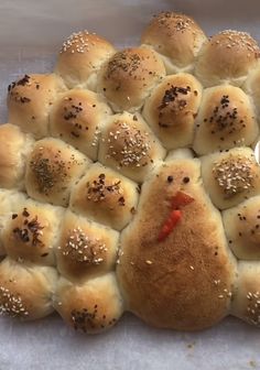 the buns have been made to look like a chicken head with sesame seeds on them