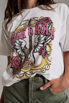 Embrace the spirit of rock and roll with our Vintage Rock and Roll Print T-Shirt in White. Crafted from 100% cotton, this tee offers not only style but also a comfortable fit. The model, with measurements 33-24-35 and a height of 5'8'', confidently sports size U, ensuring a true-to-size fit. This t-shirt boasts a regular fit and full length, making it a versatile addition to your wardrobe. The classic crew neckline and short sleeves provide a timeless look, while the relaxed fit ensures all-day Rock And, Vintage Rock, Vintage Inspired Design, Boho Vibe, Comfy Tees, Relaxed Style, Casual Wardrobe, Fast Fashion, Vintage Tshirts