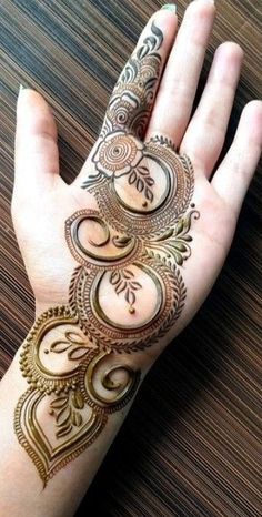 a woman's hand with henna tattoos on it