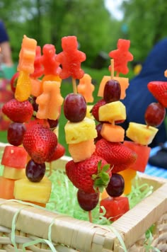 fruit skewers are arranged on sticks in a basket