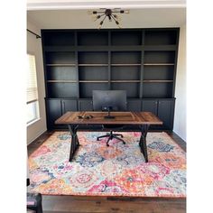 a desk with a laptop on top of it in front of some bookshelves