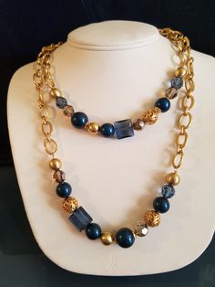 "This Fabulous Vintage Gilded Unsigned Brighton Gold Necklace is made with chains and beads. The beads are in gold, facet light blue, solid Royal Blue, gilded gold metal cut-out round bead, round facet clear topaz bead and a square transparent blue glass bead. The pattern is identical on the other side. The necklace is long so you can twist it again and double it. The chain is a solid oval and a textured oval gilded gold metal chain links. At the end is a heart shaped lobster clasp. The necklace Elegant Blue Beaded Necklaces With Chain, Blue Multi-strand Jewelry With Gold Beads, Elegant Blue Beaded Chain Necklace, Blue Double Strand Necklaces For Party, Blue Double Strand Necklace For Party, Blue Metal Beaded Chain Necklace, Blue Metal Beaded Necklaces, Blue Multi-strand Necklace With Gold Beads, Blue Beaded Metal Necklace