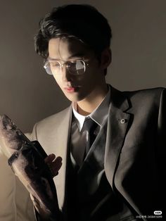 a man in a suit and tie holding a fish