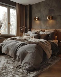 a large bed sitting in a bedroom next to a window with candles on the side