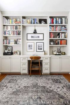 an office with white bookcases filled with books