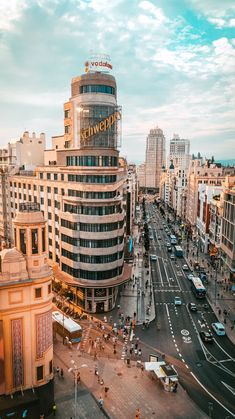 an aerial view of a city street with tall buildings and cars on the road in front of it