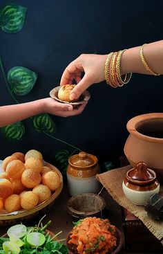 two people reaching for food on a table