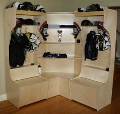 a room filled with lots of different types of sports equipment on shelves next to a wooden floor